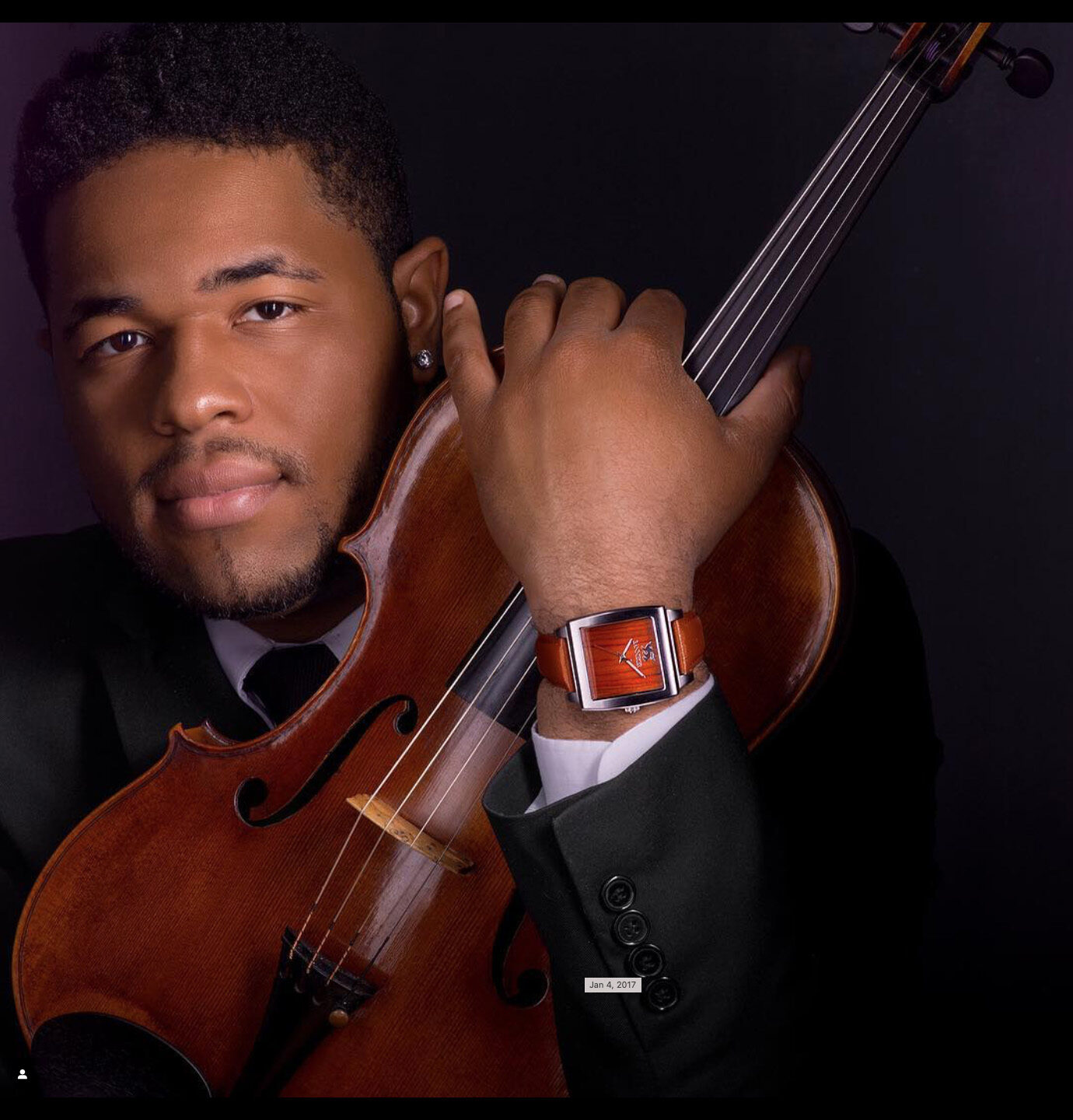 A violinist in a suit wearing a Banneker wood-faced watch
